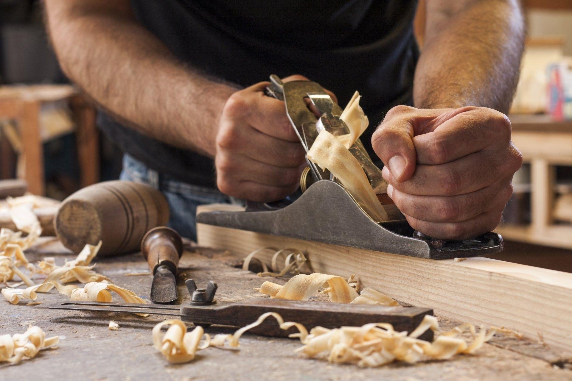 Hands planing wood in a workshop